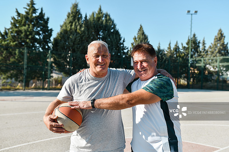 活跃的老年男性在享受篮球比赛前拥抱的肖像图片素材