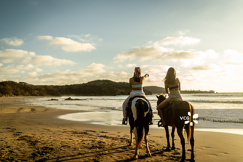 在沙滩上骑马时，女性朋友看向别处探索图片素材