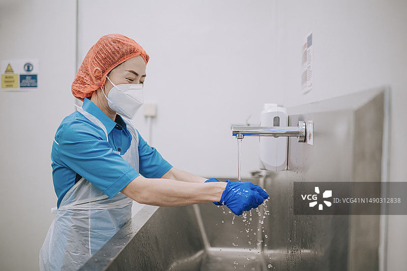 亚洲华人工厂女工在进入洁净室前洗手清洁自己图片素材