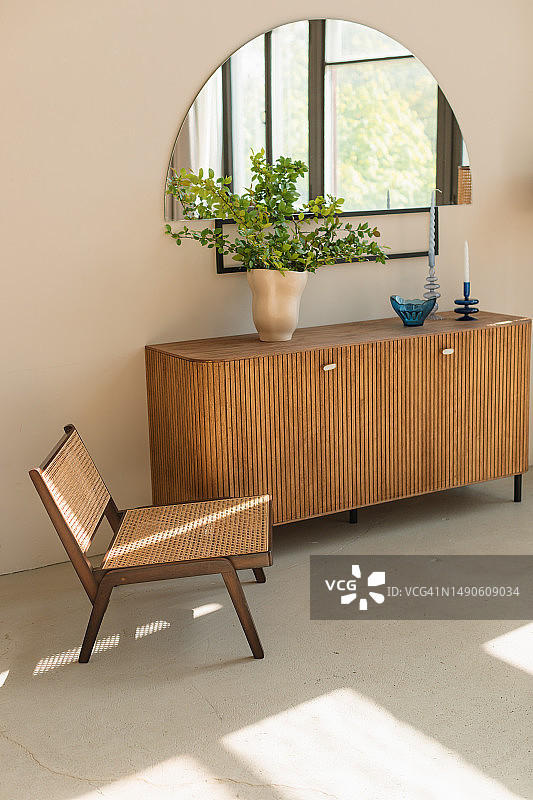 时髦的木椅，旁边的餐具柜在一个现代的客厅图片素材