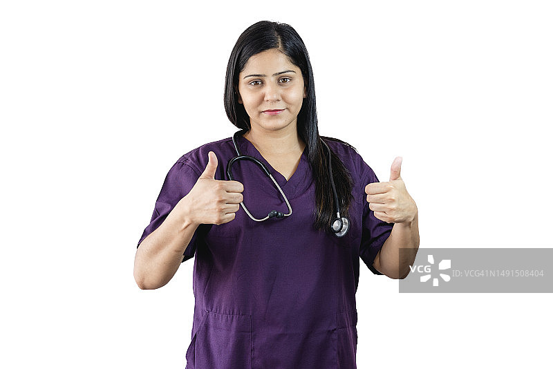 微笑的女外科医生竖起大拇指，看着镜头。图片素材