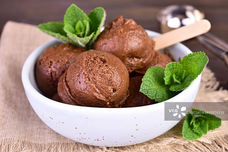 巧克力冰淇淋球和薄荷叶放在碗里。特写。图片素材