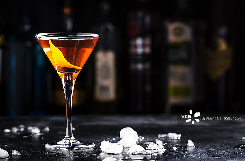 鲍比伯恩斯酒精鸡尾酒与苏格兰威士忌，苦艾酒和酒在马提尼玻璃杯，深色吧台背景图片素材