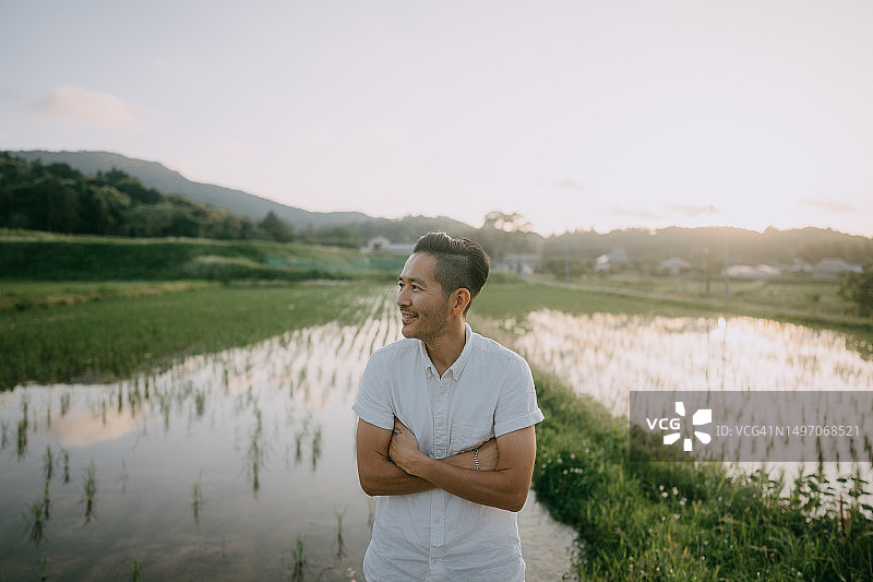日本，站在稻田前的男子图片素材