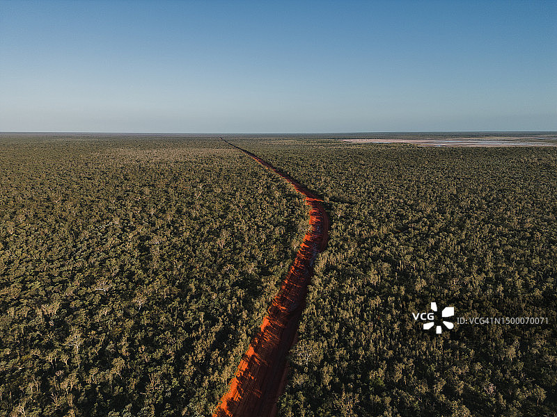 在潮湿的季节，从空中拍摄的一个阳光明媚的下午，横穿偏远荒野的土路，澳大利亚西澳大利亚图片素材