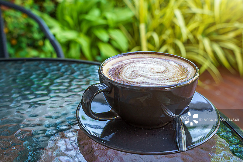 热咖啡拿铁与拉花艺术牛奶泡沫在杯子，马克杯与大理石地板背景桌子在咖啡厅咖啡厅图片素材