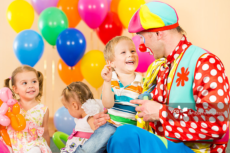快乐的孩子和小丑在生日派对上图片素材