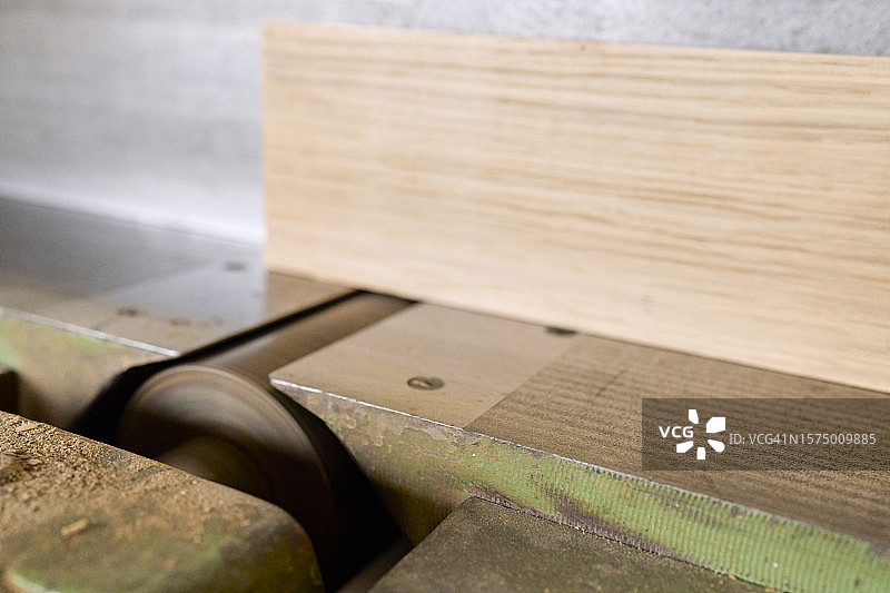 主板在木工车间的工作台上通过铣床的特写，侧面视图。图片素材