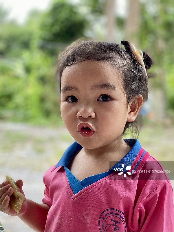 亚洲小女孩吃着用香蕉包着的糯米图片素材