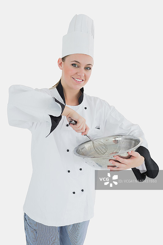快乐女厨师拿着铁丝搅拌器和搅拌碗图片素材