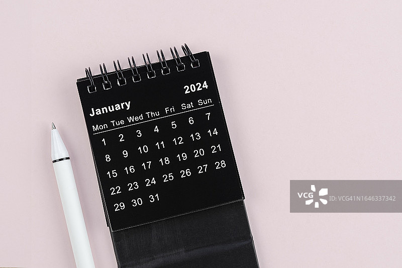 日历桌2024:1月是组织者计划和截止日期的月份，在粉红色的背景上用白色的笔。图片素材