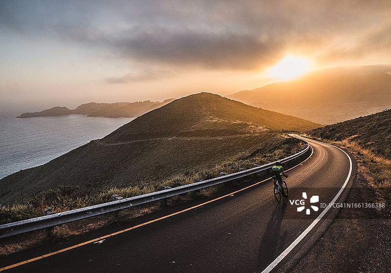日落时分，骑自行车的人在加州马林海地金门的路上图片素材