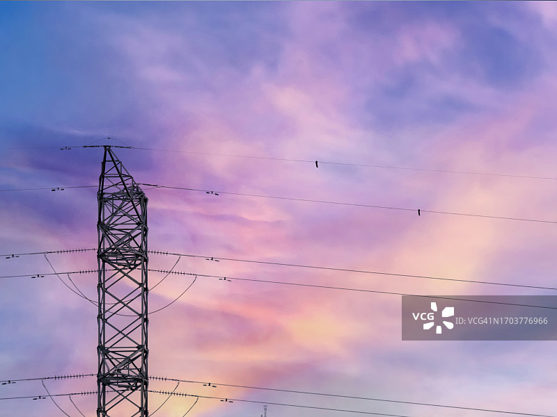 夕阳下的天空中，电站旁边的高压电塔。图片素材