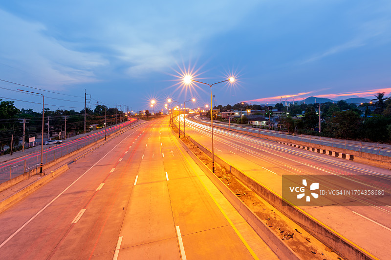 高速公路上美丽的路灯是在黄昏时汽车尾灯和车头灯的照射下形成的图片素材