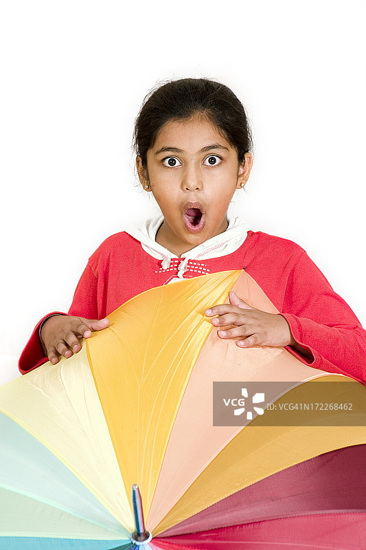震惊甜甜的印度亚洲女孩与多色伞垂直图片素材