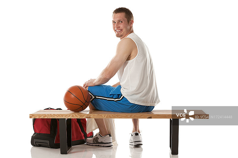 快乐的篮球运动员坐在长椅上图片素材