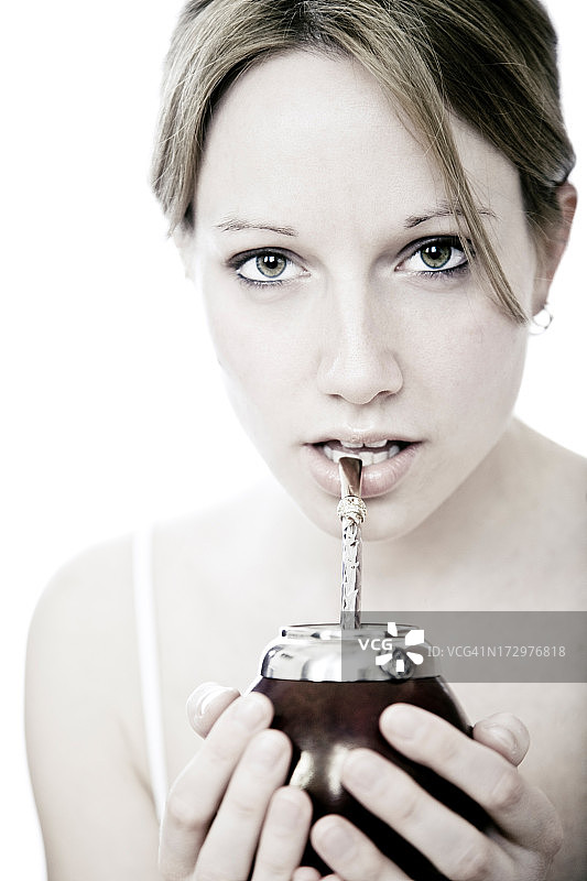 年轻女子喝着马黛茶图片素材