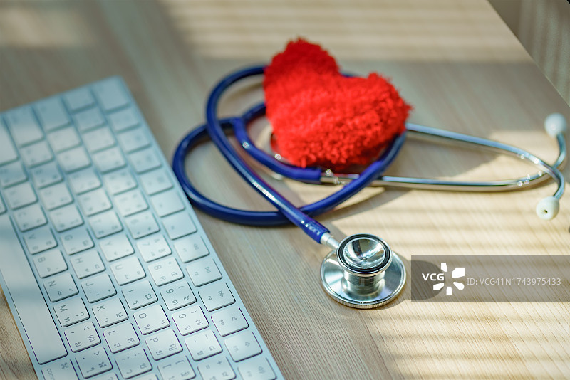 听诊器和心脏形状在笔记本电脑键盘上，心脏病专家，心脏病研究。图片素材