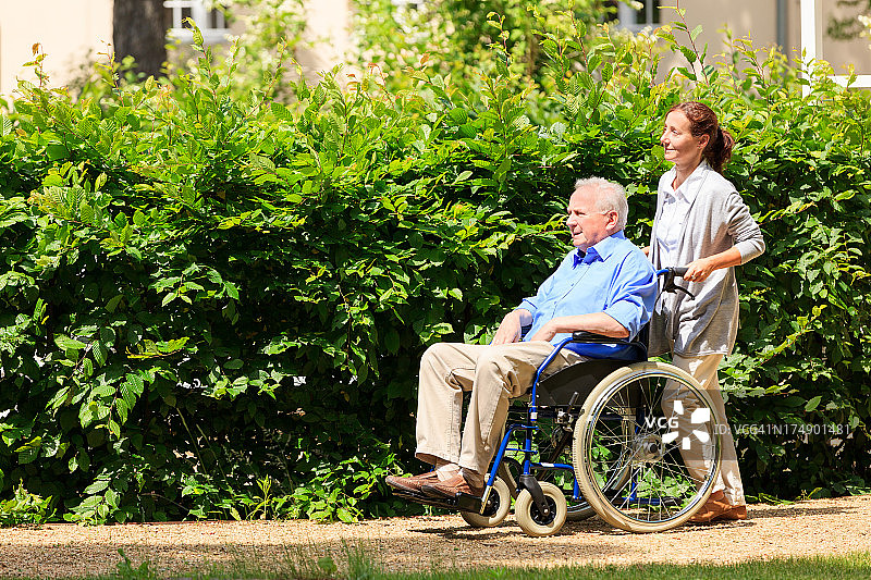 老人和护工坐在轮椅上图片素材