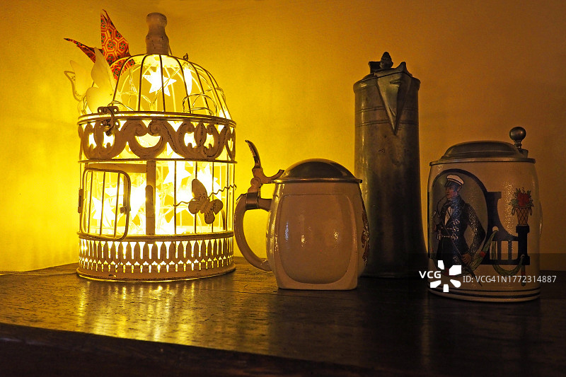 发光的鸟笼，锡罐，旧啤酒杯图片素材