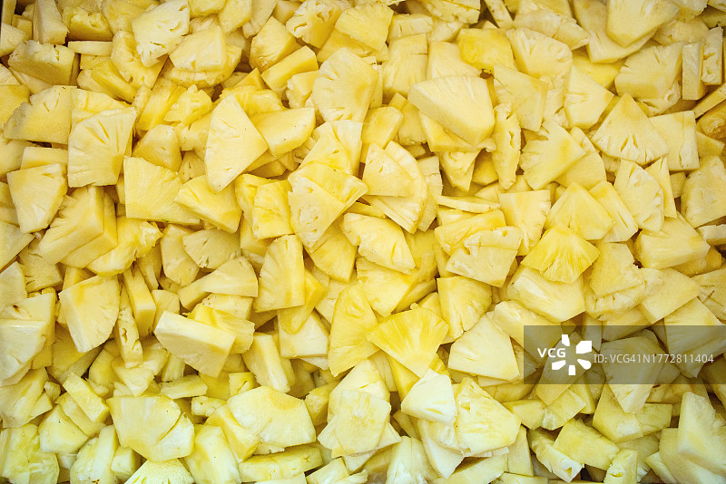 A Close-up shot of raw materials pineapple hand-cut into pineapple pieces (pizza cut) awaited to be packed into canned pineapple pieces, Pranburi district, Prachuap khiri khan Province, Thailand, Southeast Asia, Indochina图片素材