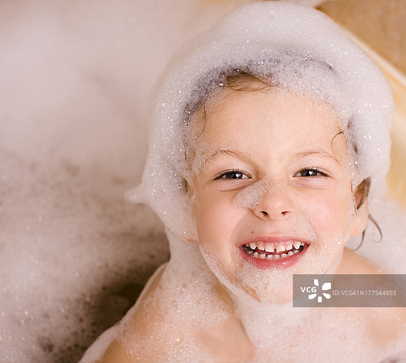 浴室里有泡沫的可爱小男孩图片素材