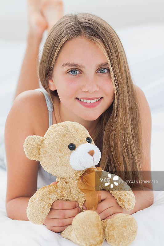 一个小女孩抱着一只泰迪熊图片素材