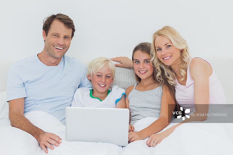 微笑的家人一起使用笔记本电脑图片素材