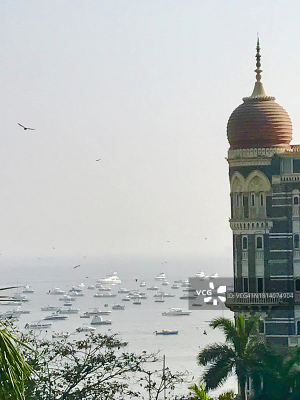 印度孟买，科拉巴，以海湾为背景的传统建筑角楼、当地植被和棕榈树。船只漂浮在印度西海岸外的阿拉伯海。2022年2月美丽的印度建筑图片素材