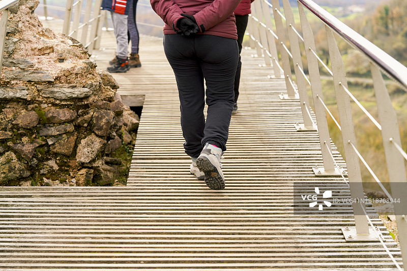 阴天，人们穿着运动鞋，爬上通往城市观光区望台的金属楼梯。图片素材