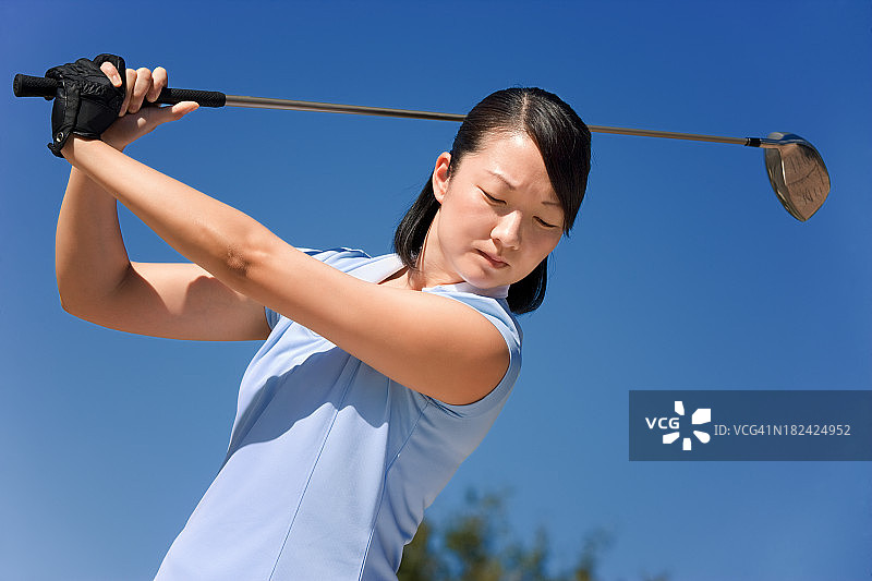 准备挥动高尔夫球杆的女高尔夫球手图片素材