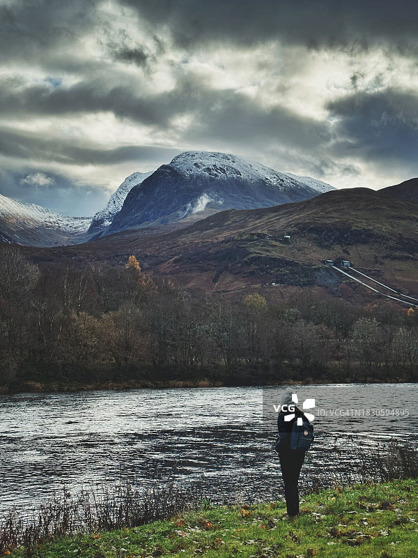 一名妇女从苏格兰洛奇河上眺望本尼维斯山的后视图图片素材
