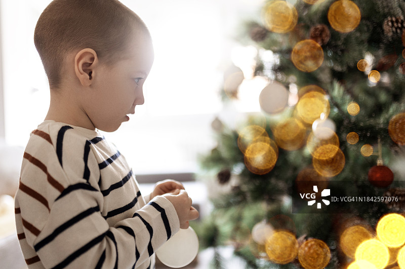 小男孩让圣诞树闪闪发光图片素材