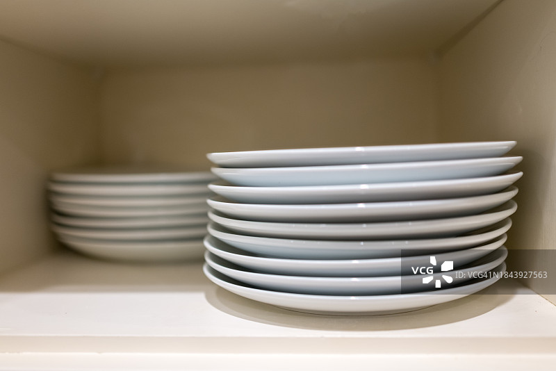 厨房橱柜里一堆堆的白色盘子图片素材