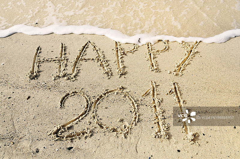 2011年新年快乐写在沙里W波浪图片素材