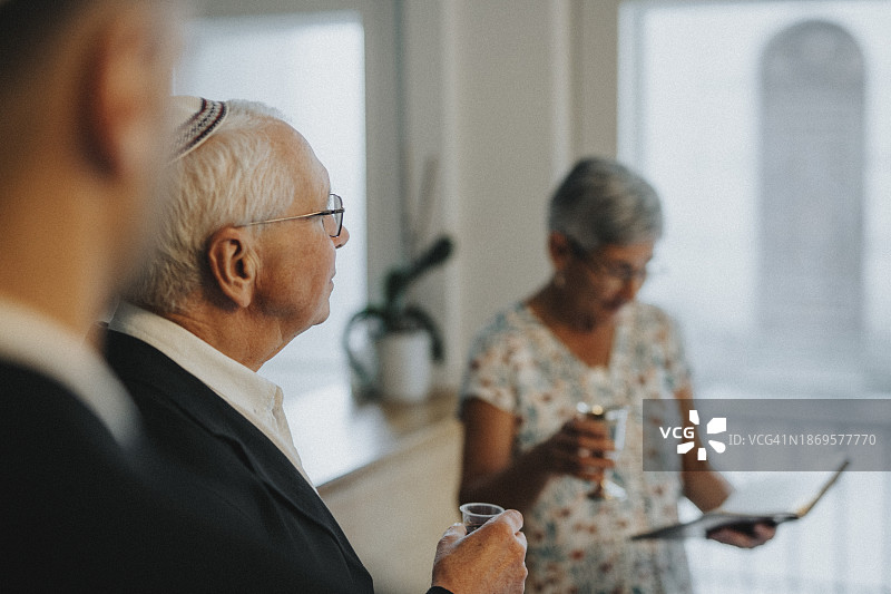 在犹太教堂举行的犹太集会上，老人拿着酒杯图片素材