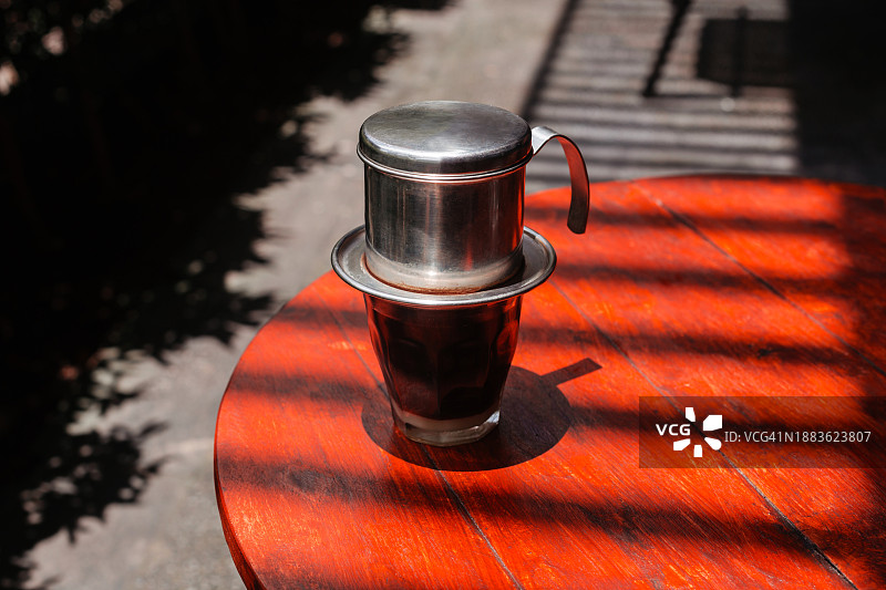 在阳光的背景下，用压滤机在木桌上冲泡黑热咖啡图片素材