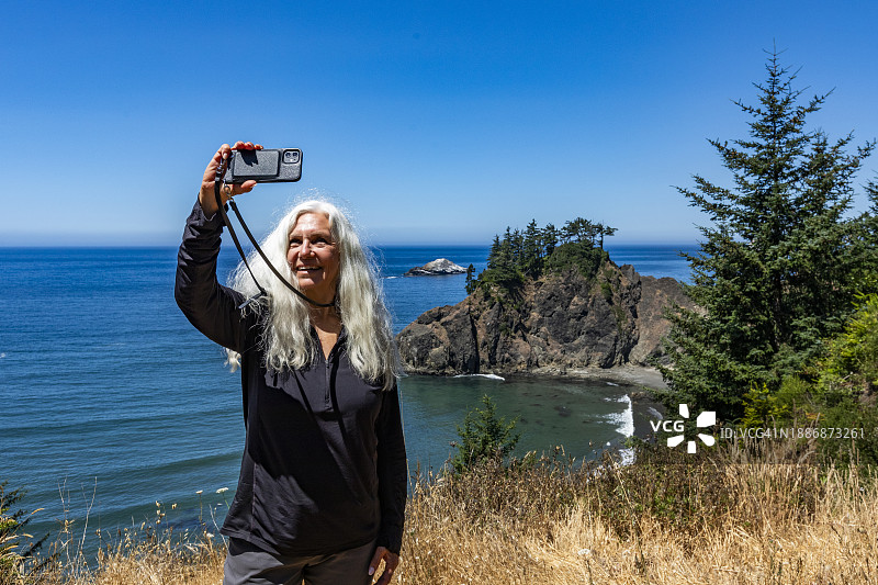 美国，俄勒冈，布鲁金斯，老年妇女自拍，以海岸景观为背景图片素材
