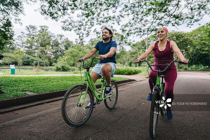 一对情侣在公园骑自行车图片素材
