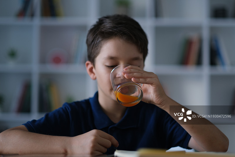 小男孩喝橙汁图片素材