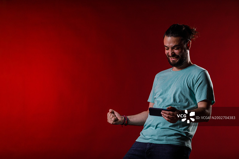 一名男子在电子游戏中赢得一关后兴奋地挥舞着拳头图片素材