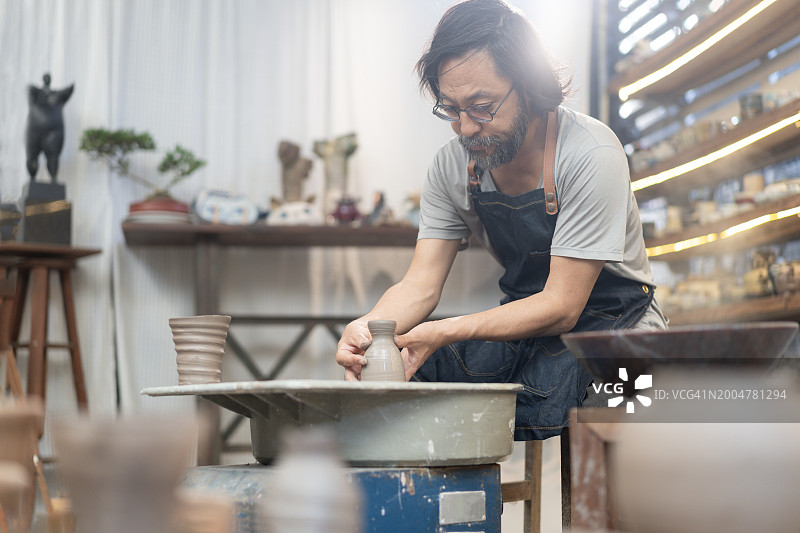 亚洲艺术家在陶艺工作室制作陶土碗图片素材