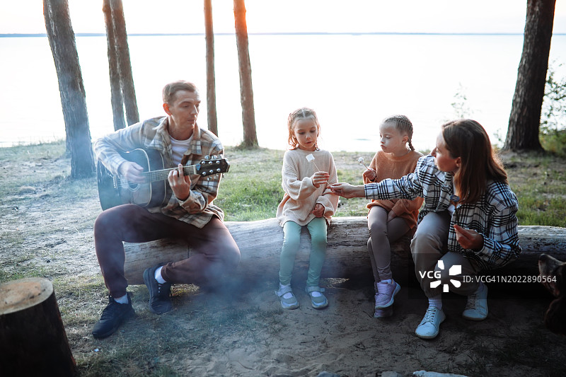 林地音乐:爸爸弹吉他，家庭时间和孩子们的户外旅行图片素材