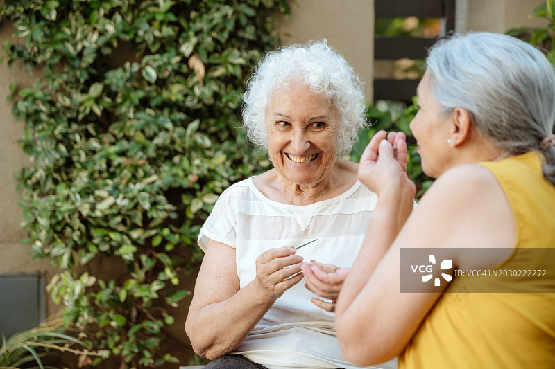 老年妇女一起在户外分享笑声和花园草药。图片素材
