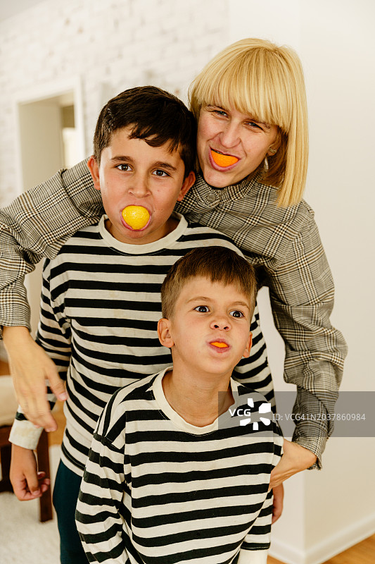 母亲在家里和儿子们做鬼脸，玩得很开心图片素材