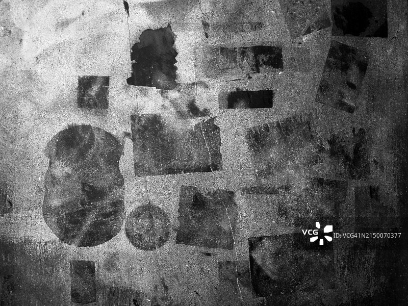 灰色石墙特写，各种几何形状的贴纸在墙上留下了胶水的痕迹。粗糙的纹理。阳光和阴影。黑白照片。巴黎,法国。图片素材