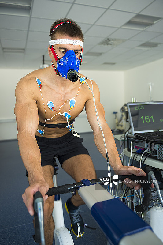 男运动员在室内自行车上进行心电图和VO2测试图片素材