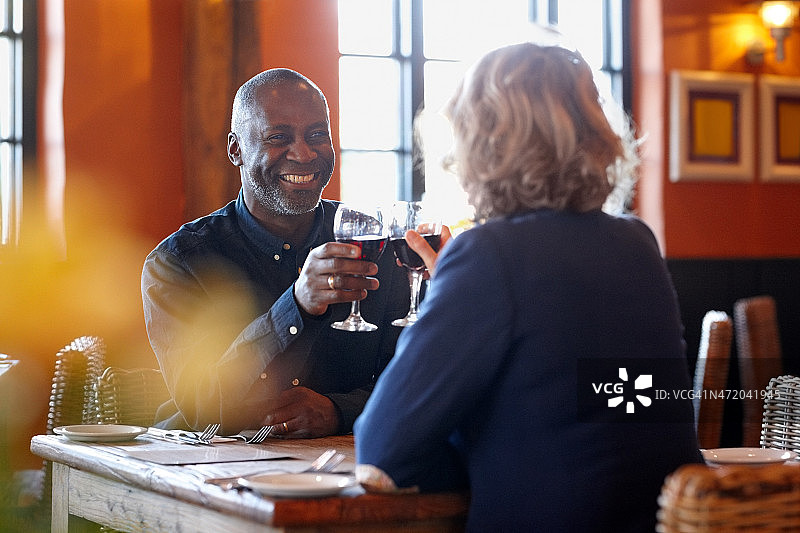 幸福的成熟夫妇在酒吧享受葡萄酒图片素材