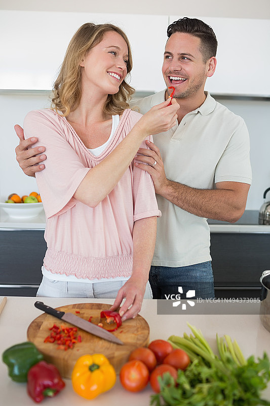 女人在厨房给男人喂辣椒图片素材