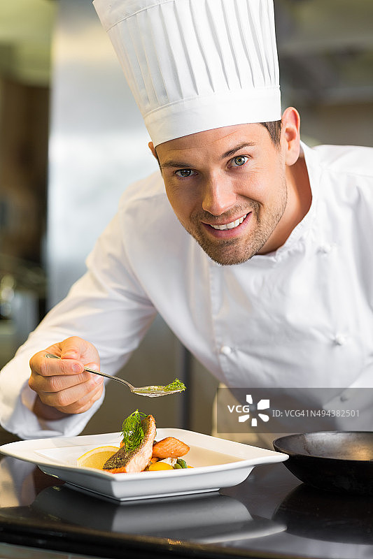微笑的男厨师在厨房装饰食物图片素材